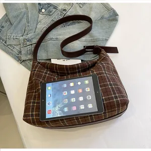 Détail du sac cabas à carreaux marron montrant sa grande capacité avec un iPad inclus
