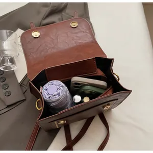 Deep brown vintage leather handbag showing spacious interior for phone and umbrella