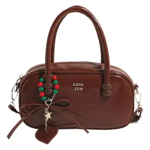 Glossy dark brown top-handle crossbody bag with COIH 2DN text and colorful charms