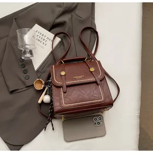Close-up of vintage brown leather backpack with contrast stitching and metal buckles