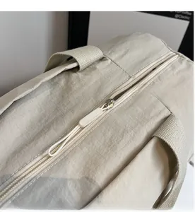 Detail of smooth metal zipper and thick woven handles on the beige yoga cylinder bag
