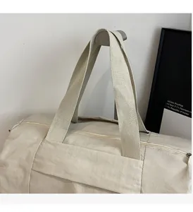 Close-up of the reinforced wide nylon handles and smooth zipper on the beige yoga bag