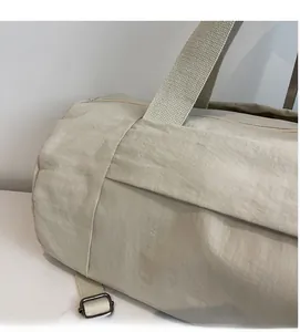 Macro shot of soft beige wrinkled nylon fabric texture and wide handle on the yoga bag