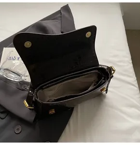 Detailansicht der dunkelbraunen Krokodilledertasche mit Magnetverschlüssen und Reißverschluss