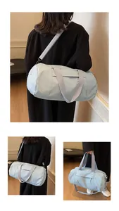 Detail view of light blue cylindrical gym bag with adjustable strap and side zipper pocket