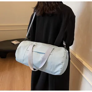 Detail of light blue cylinder gym bag with adjustable strap and metallic hardware