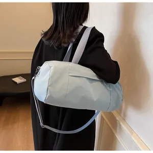 Detail of light blue cylinder sports yoga bag with adjustable straps in a lifestyle setting