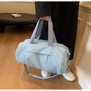 Light blue nylon yoga duffle bag with adjustable shoulder strap and hidden front zipper