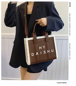 Dettaglio della borsa tote in pelle PU marrone con bordo in shearling bianco e spalline