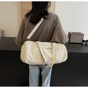 Detailed view of cream cylinder yoga bag with adjustable strap and sturdy handles