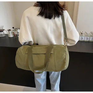 Olive green cylindrical sports yoga bag shown from back view on a female model