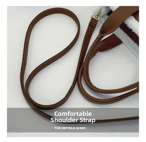 Dettaglio tracolla in pelle martellata marrone con fibbia dorata su borsa shopper