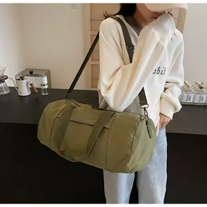Detail of army green nylon cylinder gym bag with adjustable strap and sturdy handles