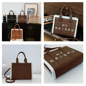 Dettaglio della borsa vintage con bordo in pelliccia, trama in pelle e scritta HY DAISHU