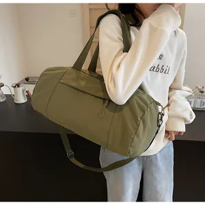 Olive green nylon yoga cylinder bag detail with adjustable shoulder strap and handle