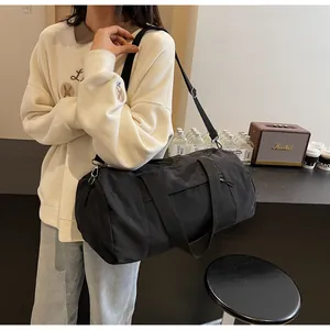 On-body view of black cylinder sports bag with durable straps in a cozy setting