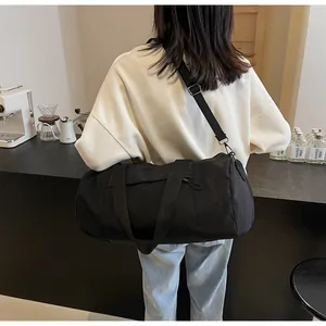 Practical black nylon barrel bag shown cross-body with adjustable strap and side pocket