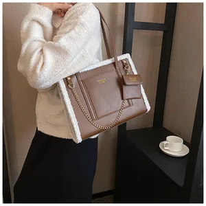 Detailed shot of brown faux leather tote with white faux fur trim and gold chain detail