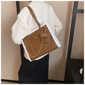 Detail of brown leather tote with white faux fur trim, chain strap and mini pouch
