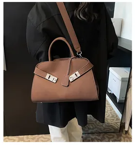 Brown leather tote bag shown as a crossbody with silver buckle and wide strap detail