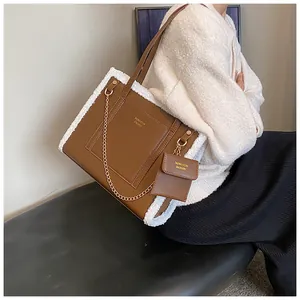 Detail view of brown faux leather tote with white faux fur trim and gold chain strap