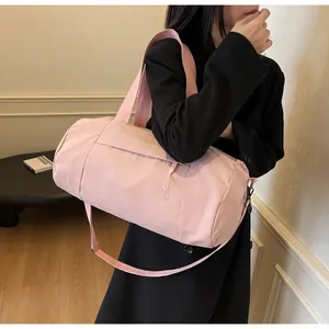 Close-up of pink cylinder sports bag featuring durable nylon fabric and front pocket
