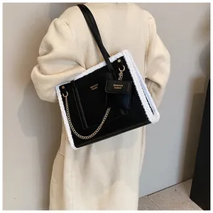Detail of black faux fur tote bag with plush trim and detachable mini pouch on model
