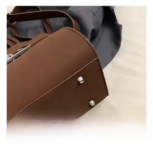 Detail of silver cone feet on a premium dark brown leather tote bag bottom