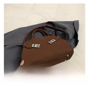 Detailed close-up of dark brown matte tote with dual silver rectangular twist locks