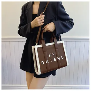 Dettaglio della borsa tote vintage con pelle marrone, finiture in lana bianca e scritta HY DAISHU
