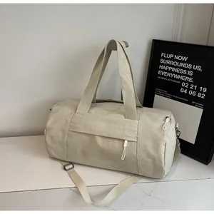 Detail view of cream yoga bag with adjustable strap and durable hardware on marble surface