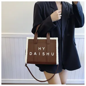 Dettaglio borsa tote in pelle marrone vintage con bordo in pile e tracolla rimovibile