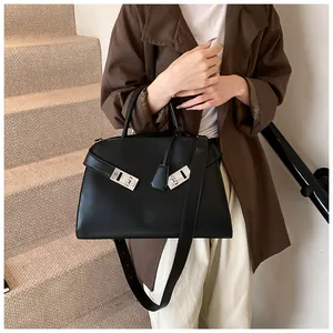 Close-up of black matte tote with silver semi-circular locks and smooth leather texture