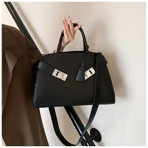 Close-up of black matte leather tote featuring a silver horseshoe clasp and sleek handle