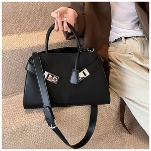 Detail of black leather tote bag with silver horseshoe buckle and adjustable strap