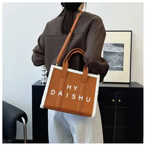 Borsa tote in pelle marrone con bordo in ecopelliccia bianca e tracolla in foto lifestyle