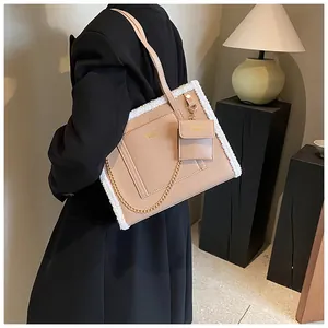 Detail of beige faux leather tote with plush lamb wool trim and golden chain strap