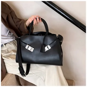Detail of black tote bag with silver interlocking buckles and removable shoulder strap