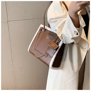Detail of retro brown faux leather tote with white plush trim and metal chain accessory