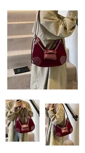 Detalle de bolso hobo de terciopelo burdeos con cadena plateada y mini estuche colgante