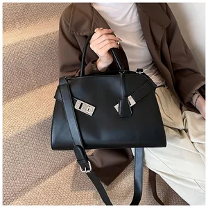 Detail of black leather handbag with silver metallic clasps and detachable shoulder strap