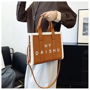 Dettaglio della borsa tote vintage marrone con bordo in pile bianco e logo HY DAISHU