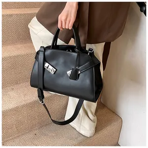 Detail of a black matte leather tote bag with asymmetric silver buckle and strap