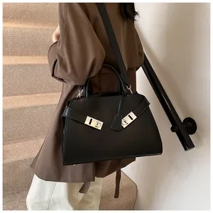 Detail of black leather tote bag with silver double-ring hardware on a model