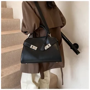 Detail of black trapezoid tote bag with silver Gancini buckle and wide leather strap
