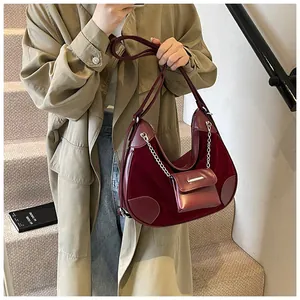 Detalle de bolso hobo granate vintage con textura de terciopelo y cadena de plata fina