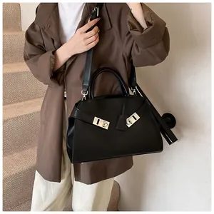 Close-up of black leather handbag with silver Gancini-style buckle and wide shoulder strap