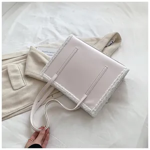 Close-up of a cream faux leather tote bag with soft plush fur trim and thin straps