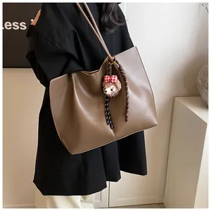 Detail of dark brown tote bag in matte synthetic leather with long shoulder straps