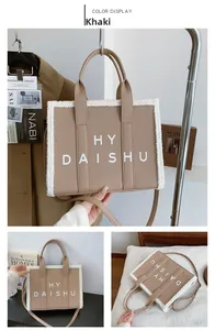 Dettaglio borsa tote kaki con bordo in peluche bianco e stampa "HY DAISHU" centrale